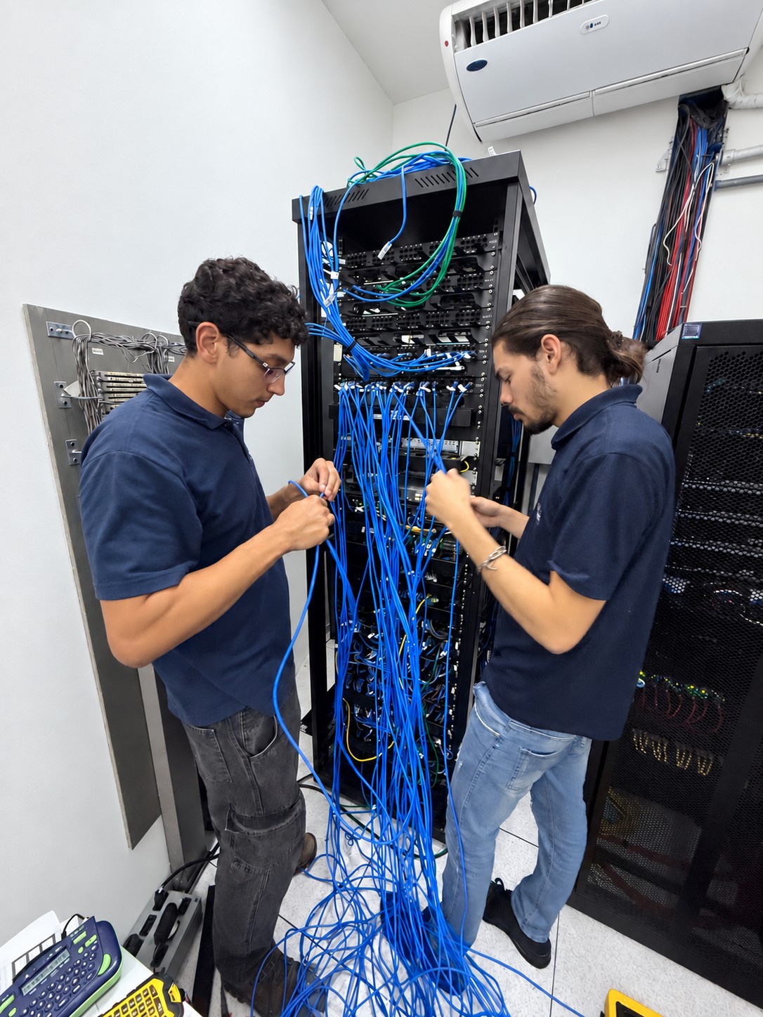Equipe da Skills trabalhando nas conexões do rack de uma unidade educacional
