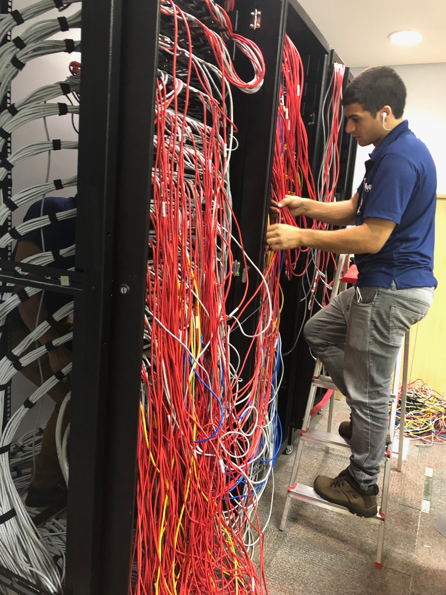 Profissional da Skills durante a reorganização do cabeamento do rack